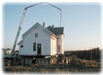 The house being steadied by a crane