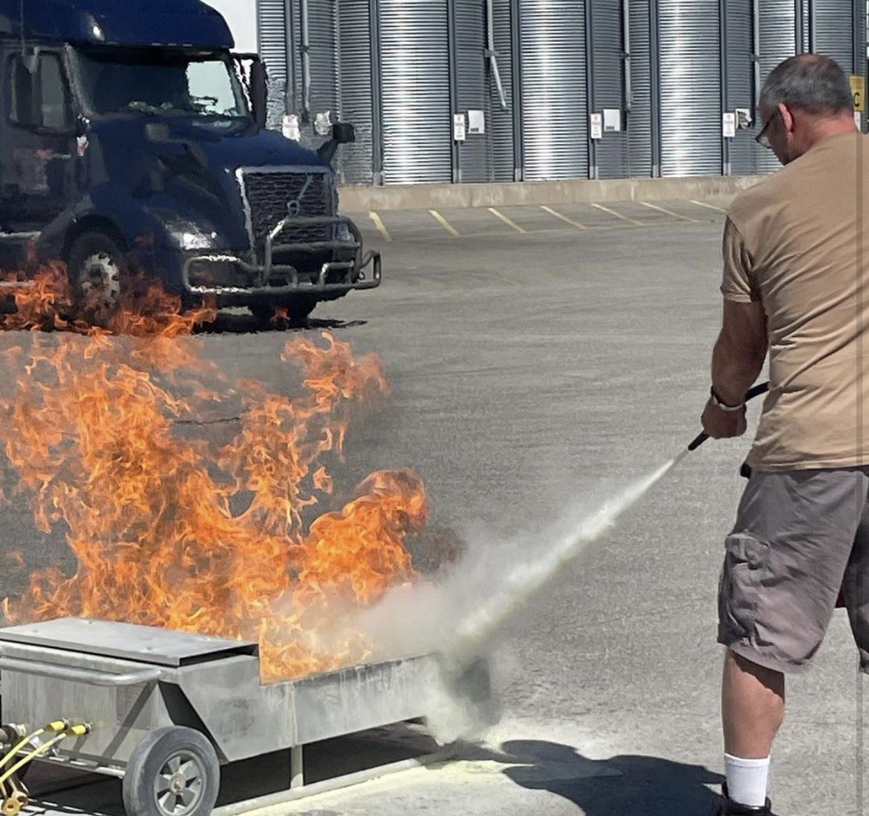 Man putting out flames with fire extinguisher